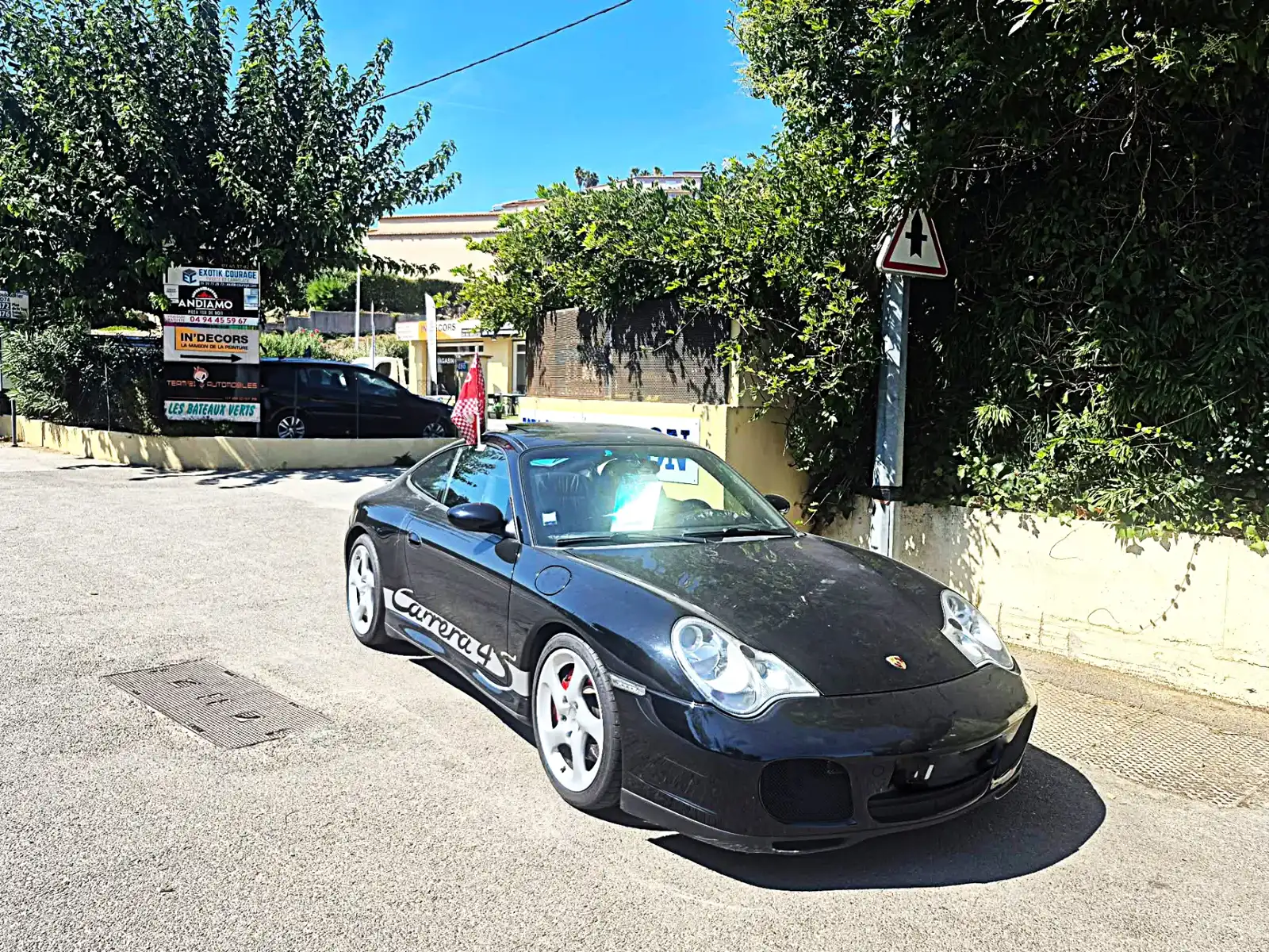 Porsche 911 Carrera 4S noire devant le garage TEAM #21 AUTOMOBILES à Sainte-Maxime